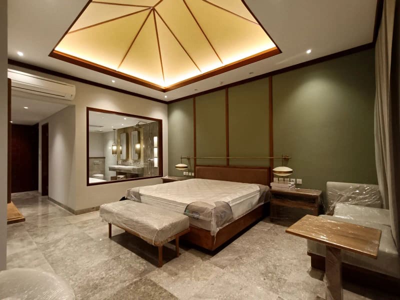 Kamar tidur villa pada tahap finishing dengan perabot masih terbungkus pelindung