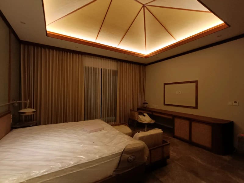 Kamar utama villa dengan tempat tidur, meja rias, dan plafon kayu menjelang serah terima